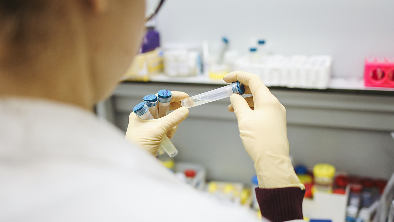 CQM Researcher holding test tubes.